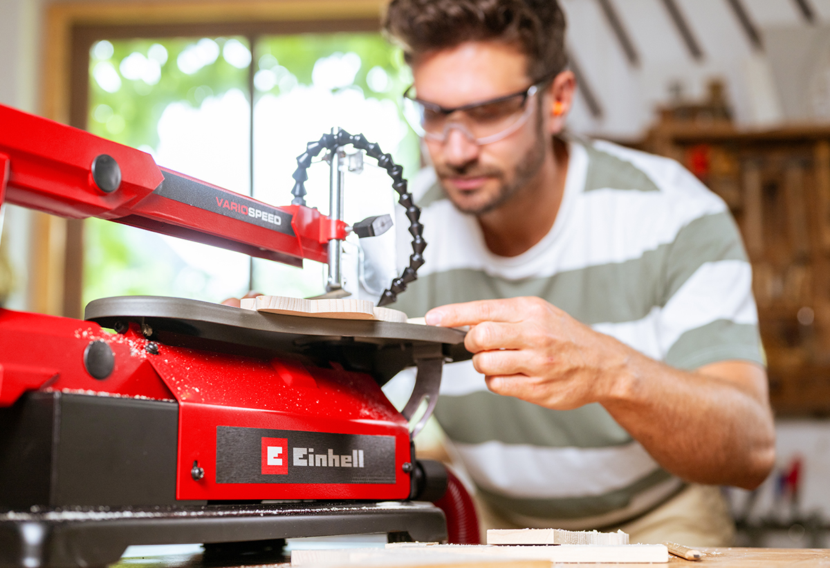 Απεικονίζεται άνδρας να χρησιμοποιεί τη σέγα σε ξύλινη επιφάνεια.